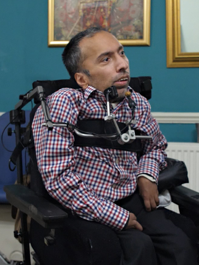 A man in a power chair in his home