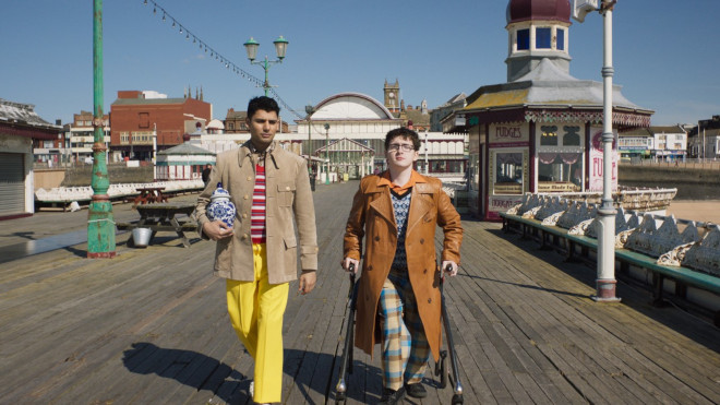 Two young men walking side by side on a pier